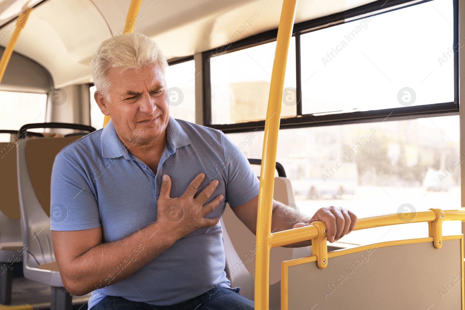 Image of Senior man having heart attack in public transport