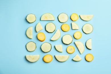 Photo of Fresh ripe cut zucchinis on light blue background, flat lay