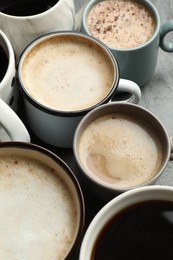 Many cups of different coffees on slate table