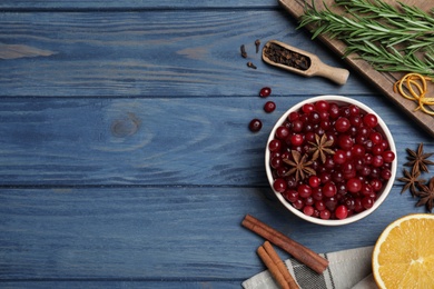 Flat lay composition with fresh ripe cranberries on blue wooden table. Space for text
