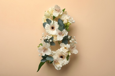Photo of Number 8 made of beautiful white flowers on beige background, flat lay. International Women's day