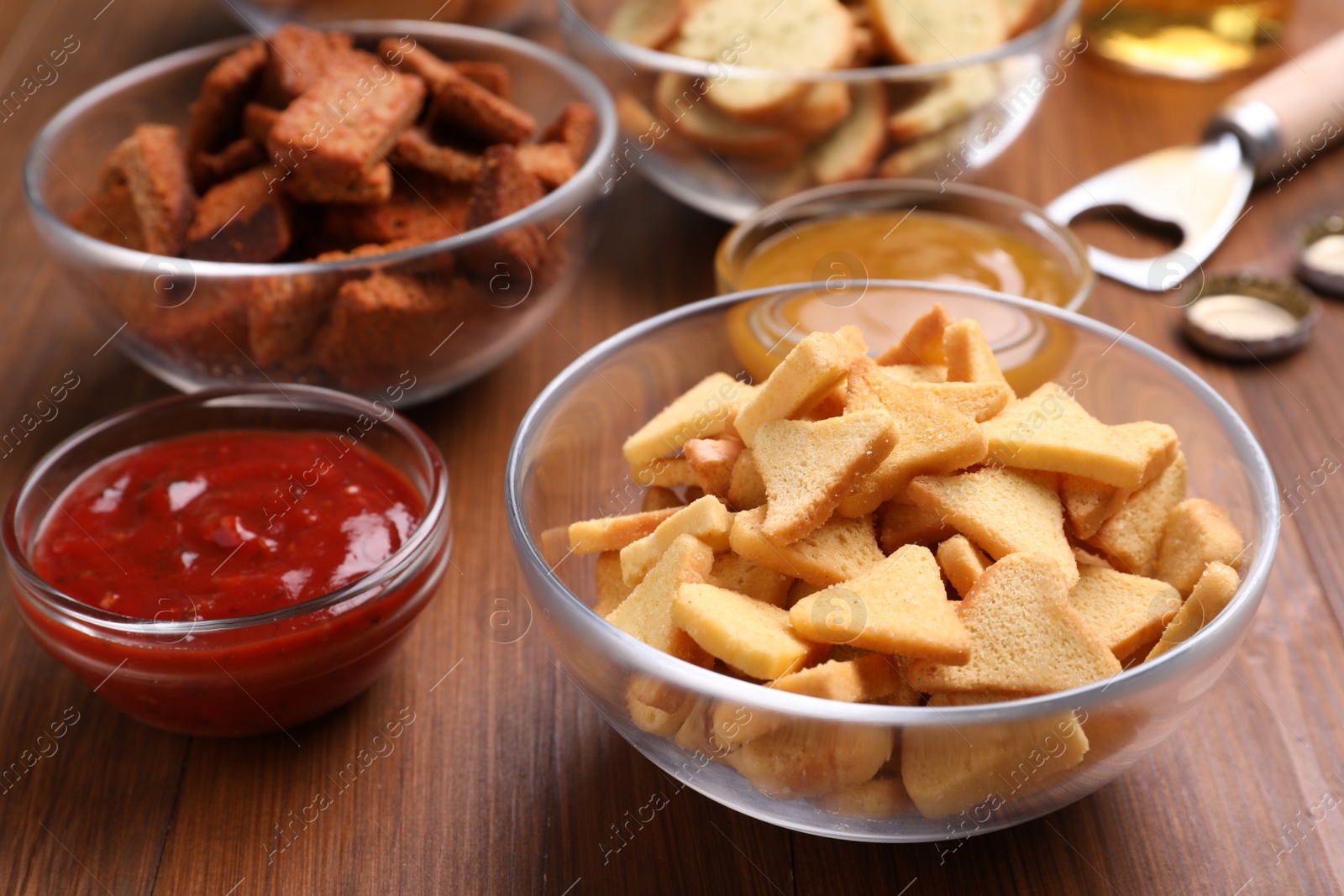 Photo of Different crispy rusks and dip sauces on wooden table