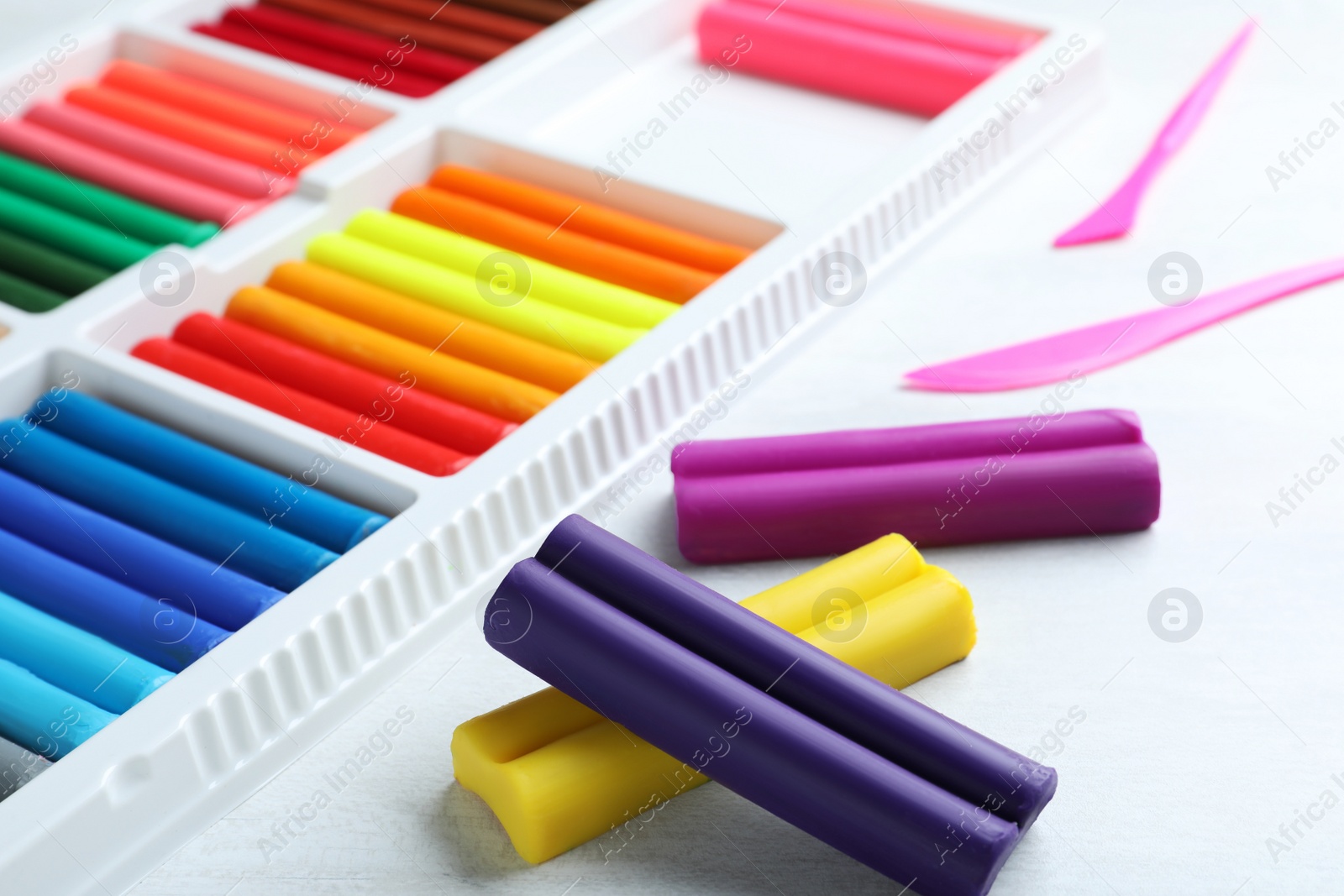 Photo of Colorful plasticine and tools on white table