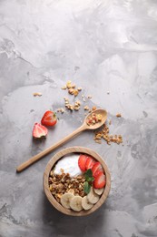 Tasty granola served on gray textured table, flat lay. Space for text