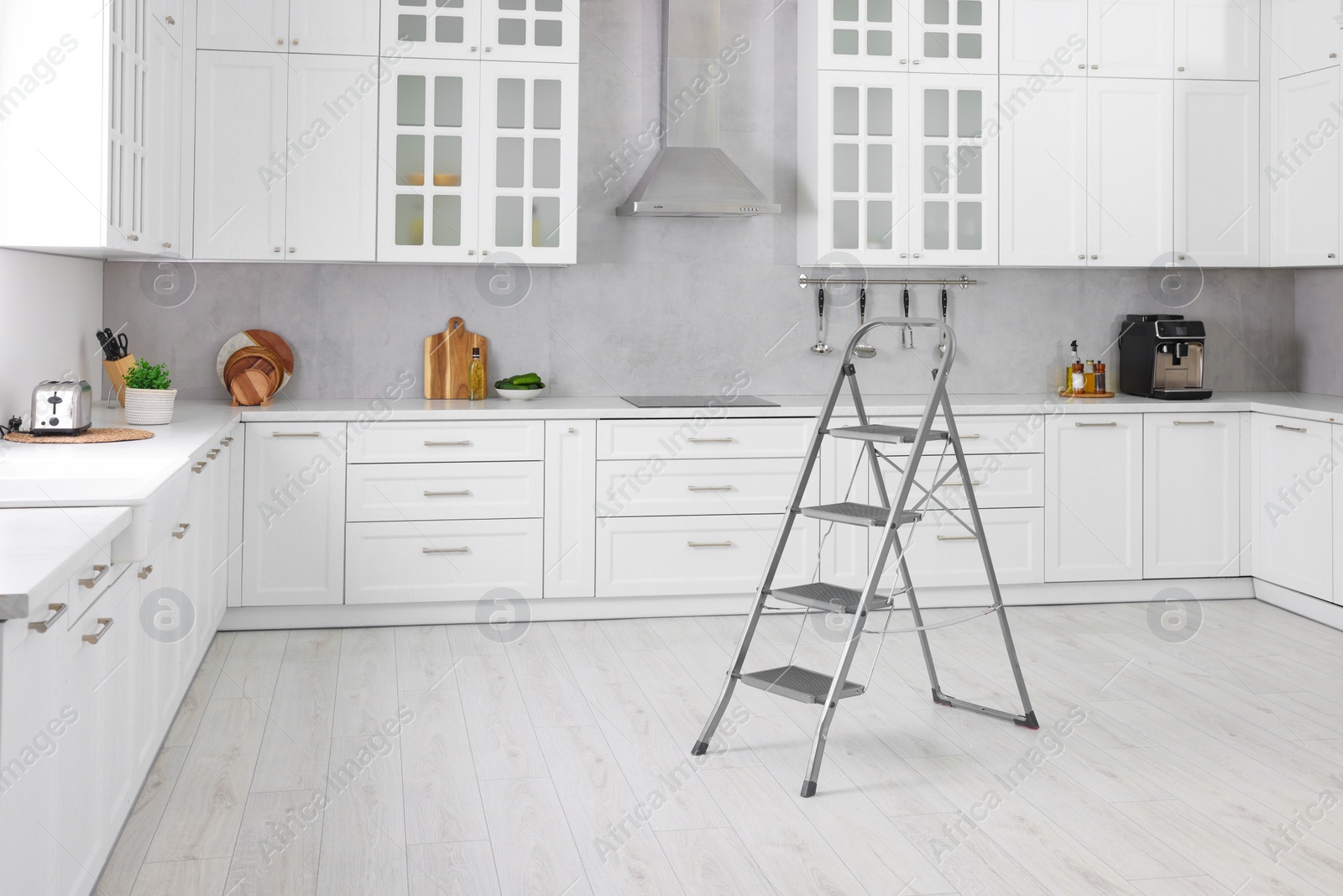 Photo of New metal stepladder on floor in kitchen