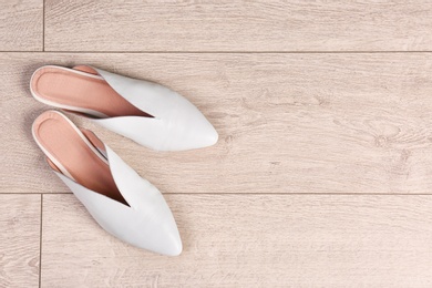 Pair of female shoes on wooden background, top view