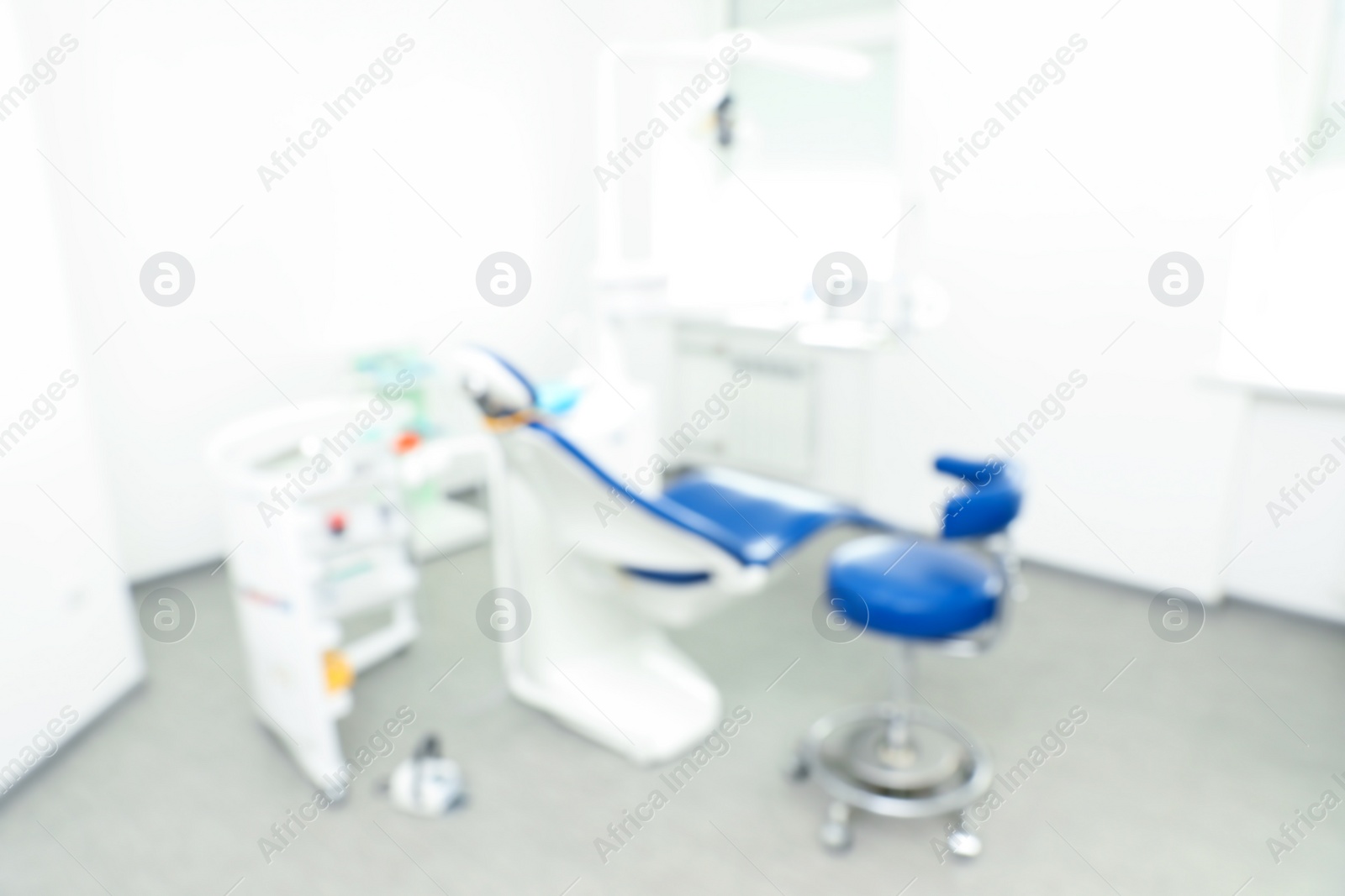 Photo of Blurred view of dentist's office interior with chair and equipment