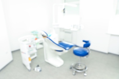 Photo of Blurred view of dentist's office interior with chair and equipment
