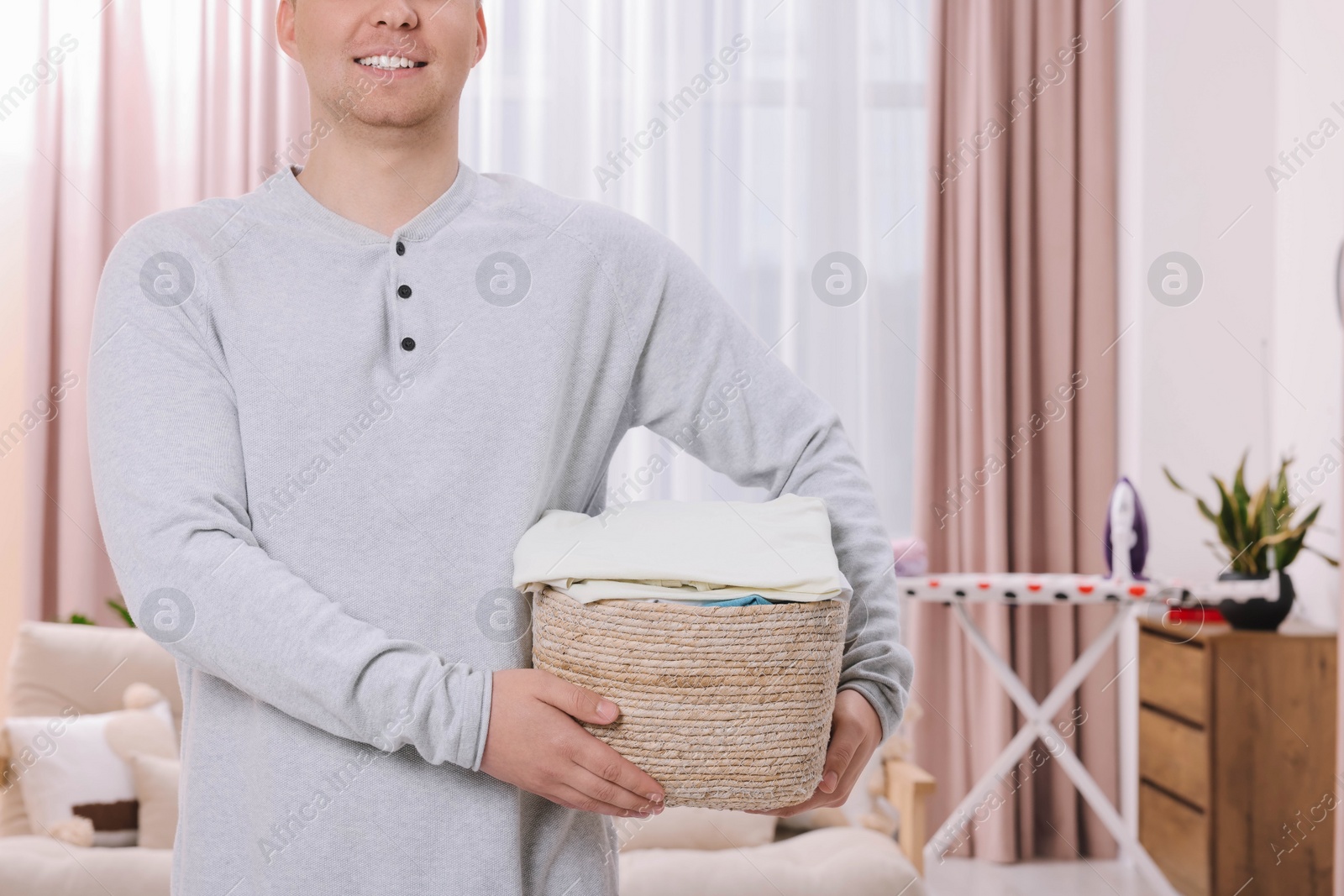 Photo of Man with basket full of laundry at home, closeup