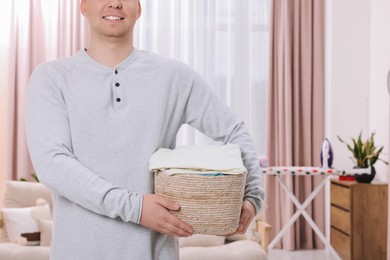Man with basket full of laundry at home, closeup