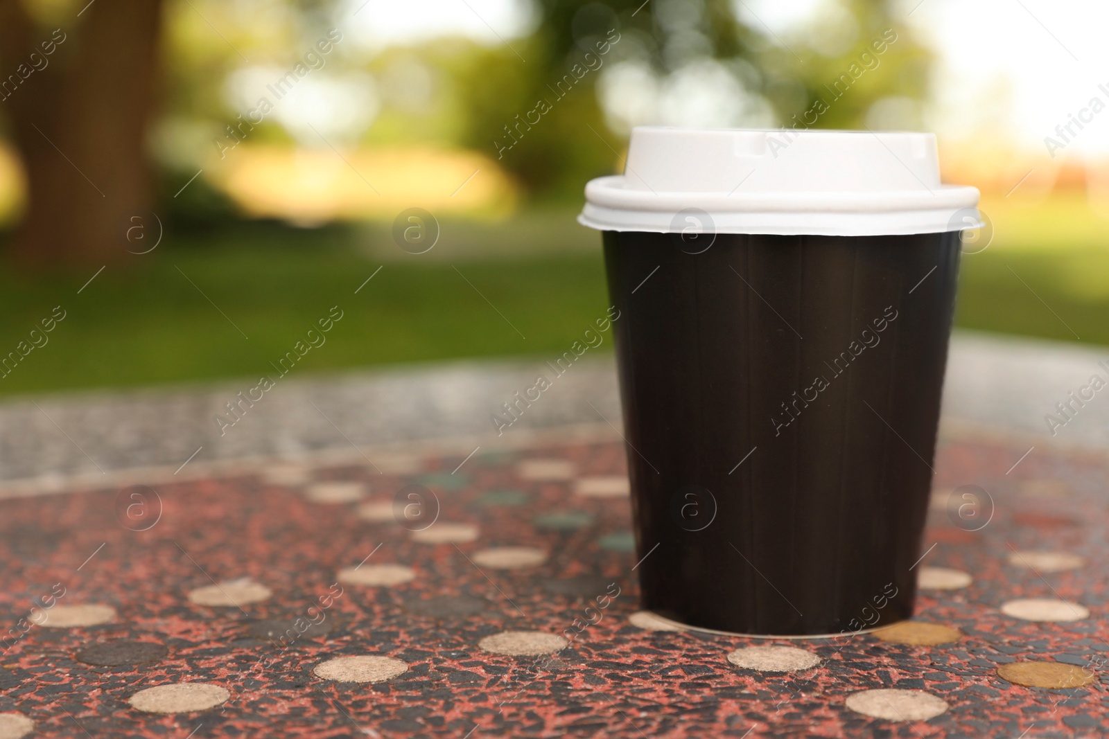 Photo of Paper cup on stone table, space for text. Coffee to go