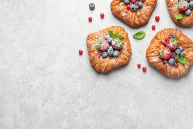 Fresh delicious puff pastry with sweet berries on light background, flat lay. Space for text