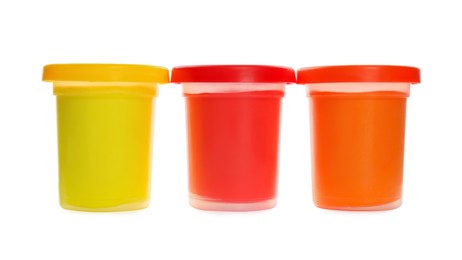 Plastic containers with different color play dough isolated on white