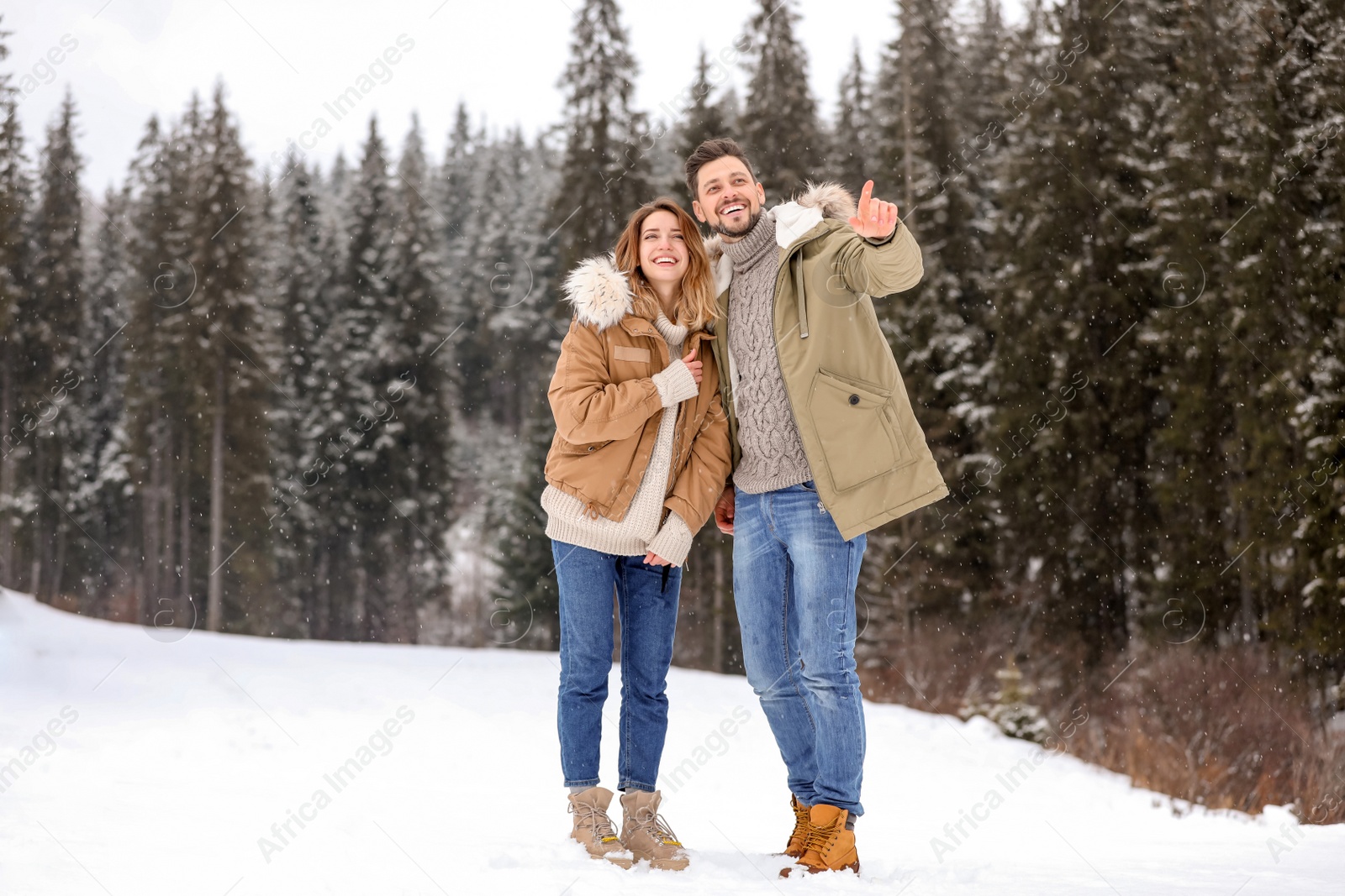 Photo of Couple spending time outdoors on snowy day. Winter vacation