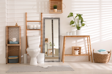 Interior of stylish bathroom with toilet bowl and decor elements