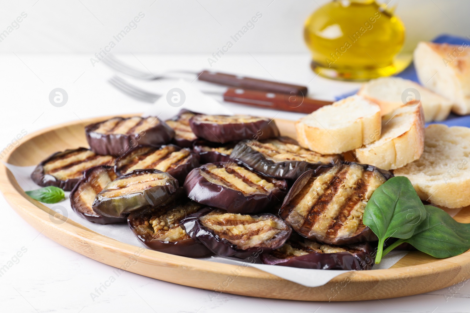 Photo of Delicious grilled eggplant slices served on white table, closeup