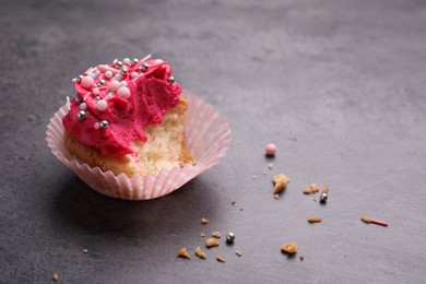 Photo of Failed cupcake with cream on grey table. Troubles happen