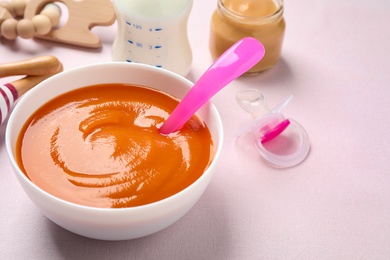 Photo of Healthy baby food in bowl on light table