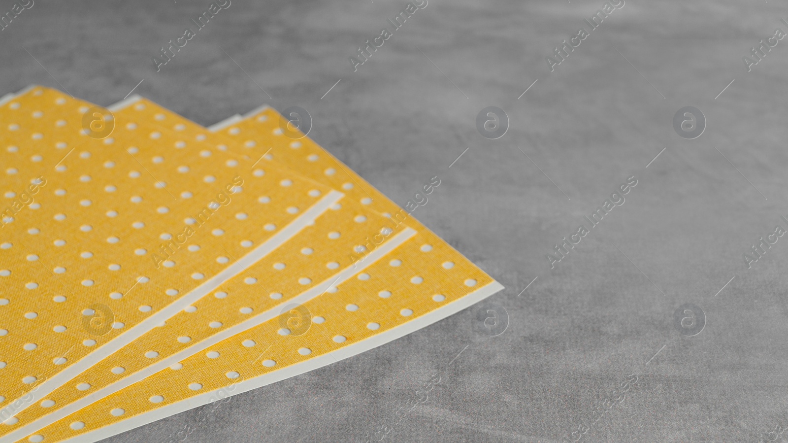 Photo of Pepper plasters on grey textured background, closeup. Space for text