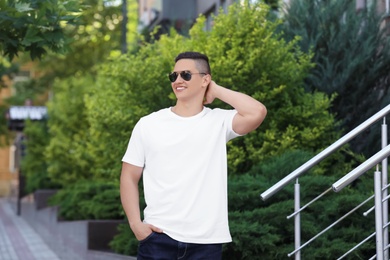 Photo of Young man in white t-shirt outdoors. Mockup for design