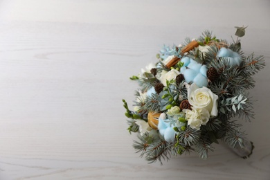Photo of Beautiful wedding winter bouquet on white wooden table, top view. Space for text
