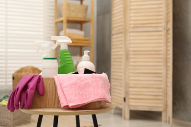 Different cleaning products in wooden box on table indoors, space for text