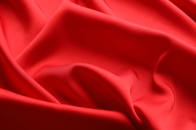 Photo of Crumpled red silk fabric as background, closeup