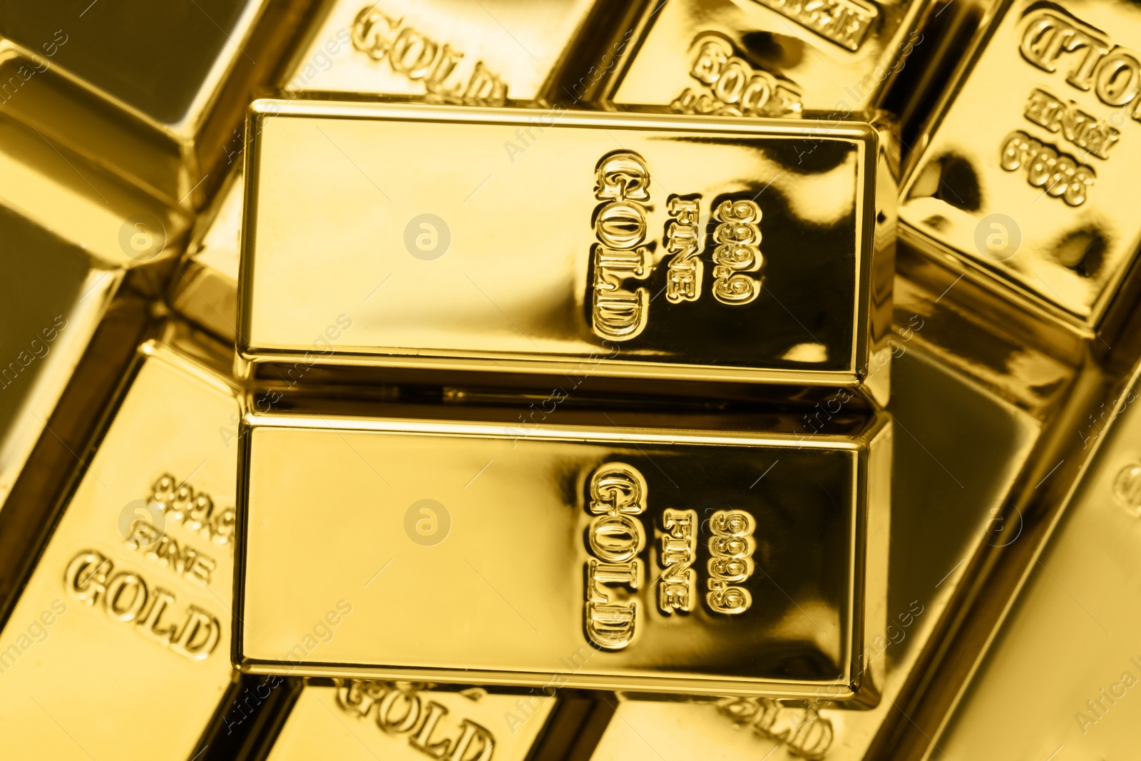 Photo of Many shiny gold bars as background, top view