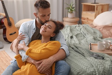 Photo of Lovely couple enjoying time together on floor in bedroom