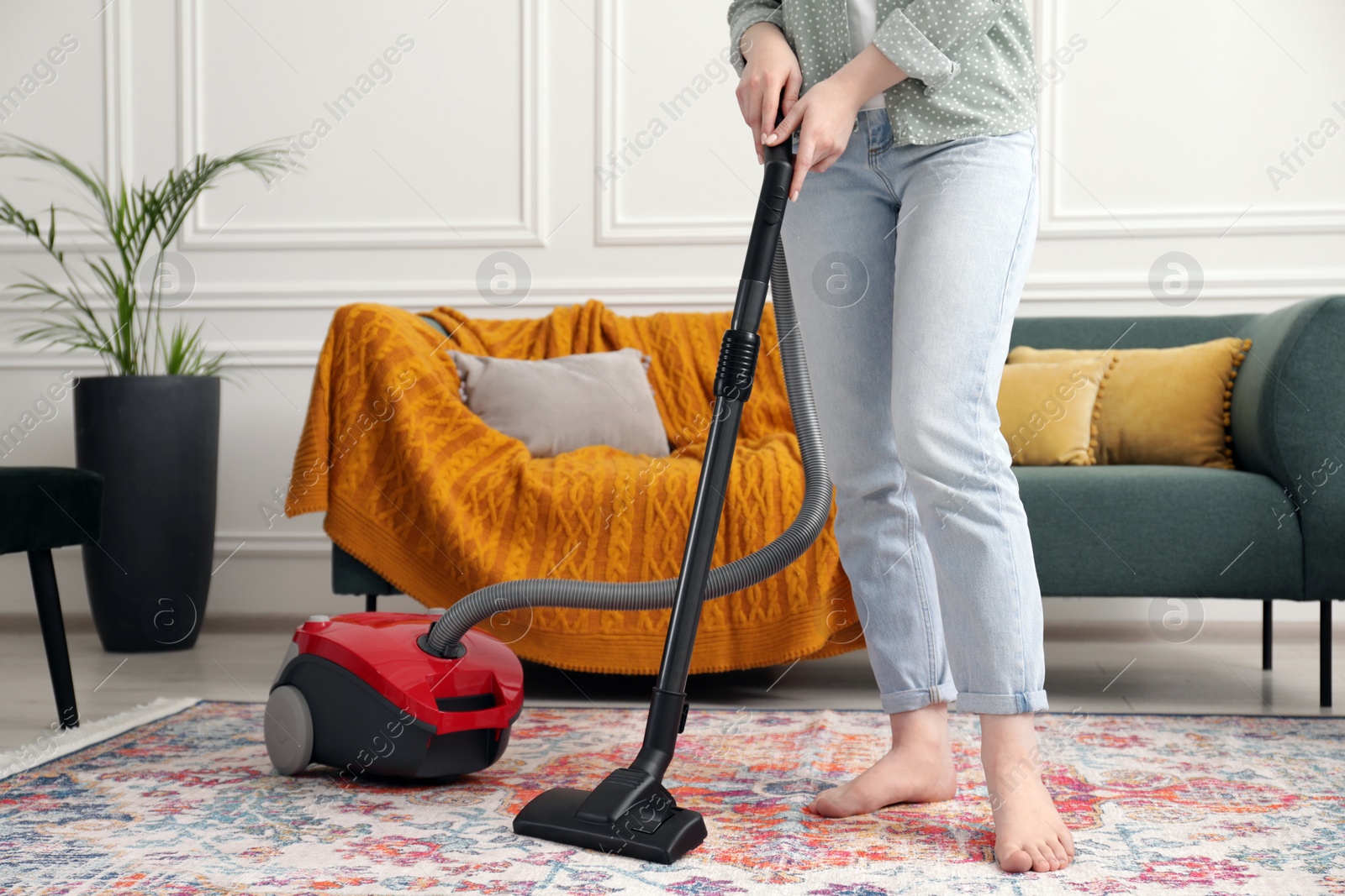 Photo of Woman cleaning carpet with vacuum cleaner at home, closeup