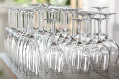 Photo of Empty glasses on wooden table against blurred background