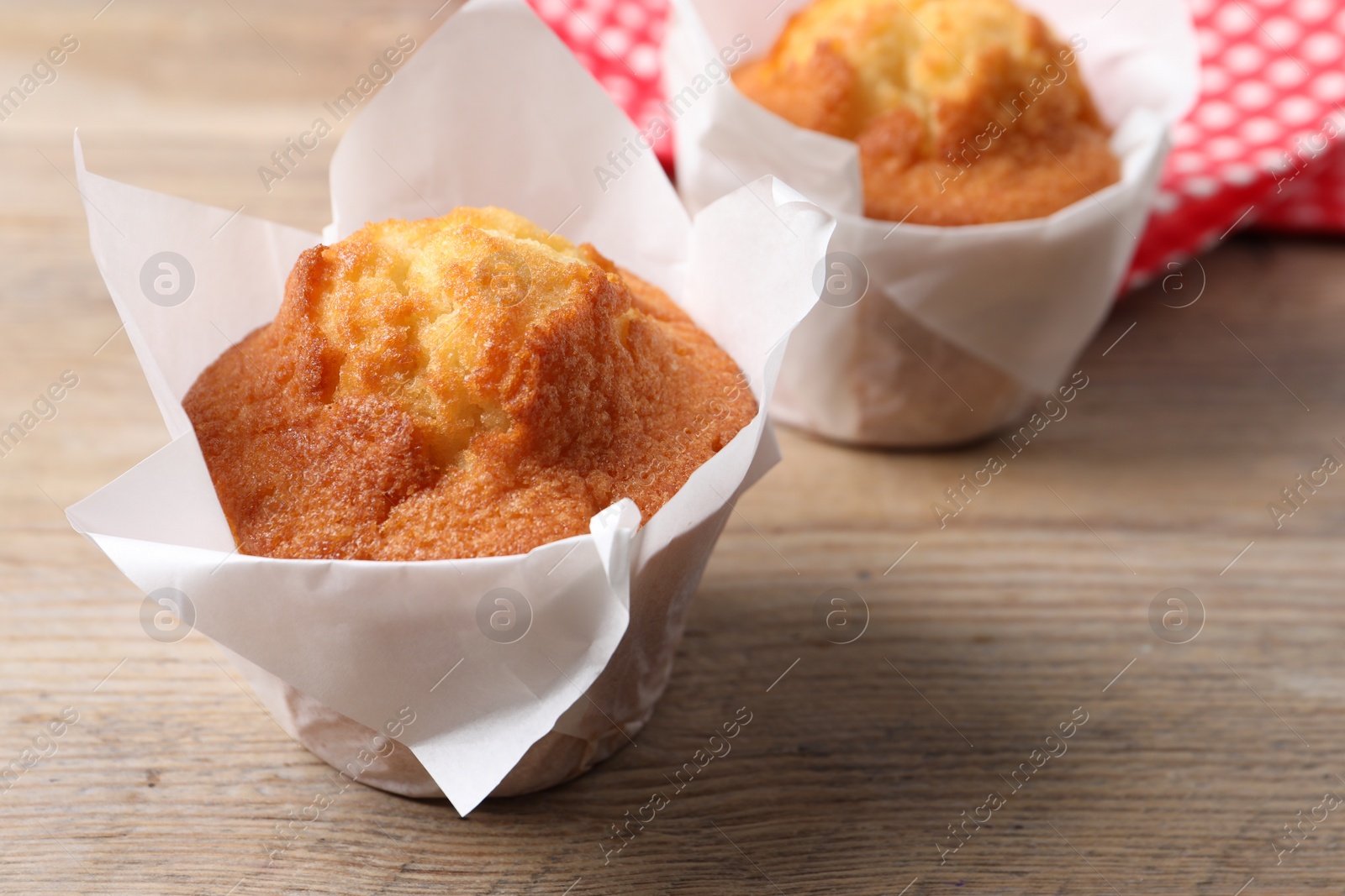 Photo of Delicious sweet muffins on wooden table, closeup. Space for text