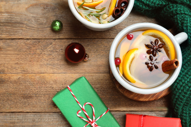 Aromatic mulled wine on wooden table, flat lay