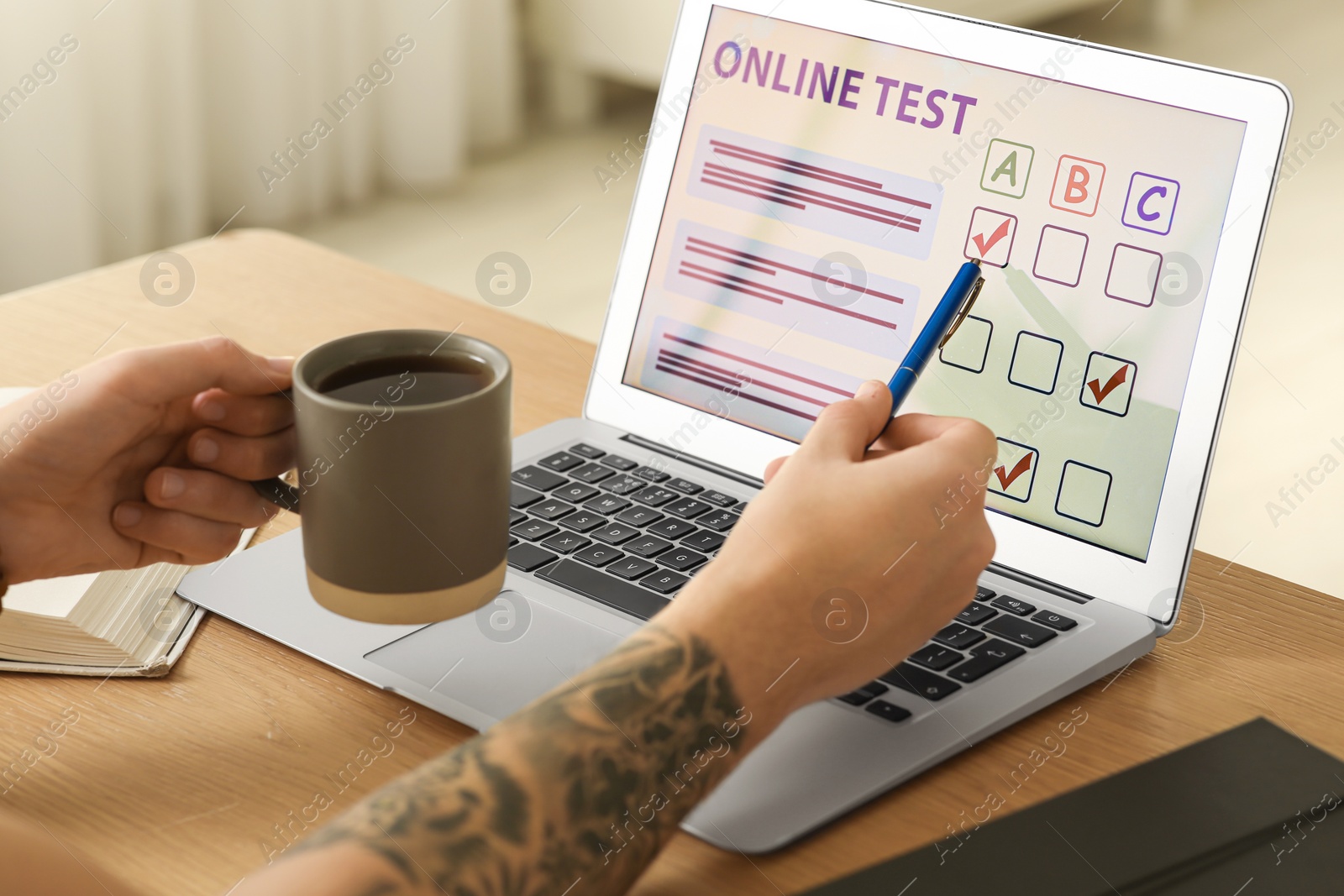 Photo of Man taking online test on laptop at desk indoors, closeup