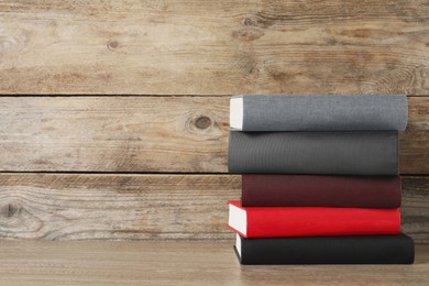 Photo of Stack of hardcover books on wooden table, space for text