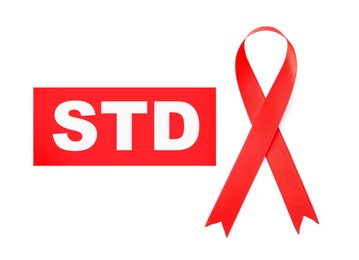 Image of Red awareness ribbon and abbreviation STD on white background, top view 