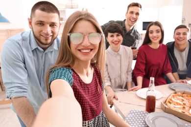 Happy friends taking selfie indoors