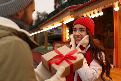 Photo of Lovely couple with Christmas present at winter fair