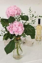 Beautiful pink hortensia flowers in vase on kitchen counter