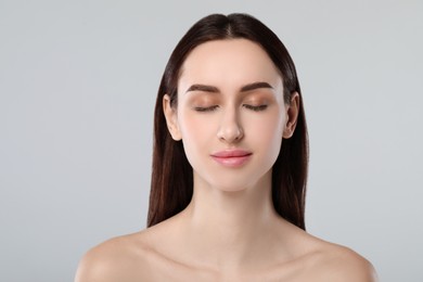 Portrait of beautiful young woman on light grey background