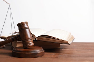 Wooden gavel, scales of justice and books on table. Law concept