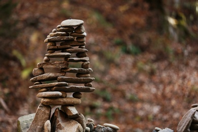 Photo of Tower of balancing stones in forest. Space for text