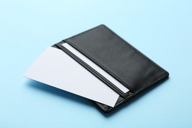 Photo of Leather business card holder with blank cards on light blue background