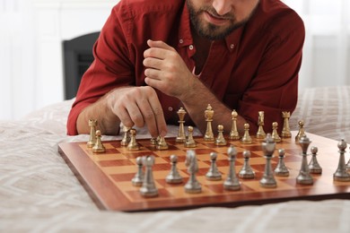 Photo of Man playing chess alone on bed at home, closeup