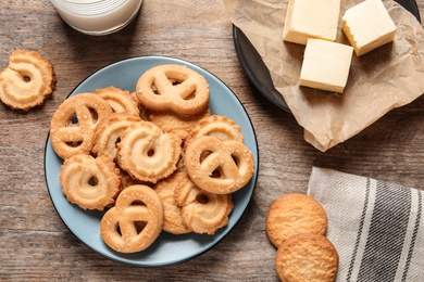 Plate with Danish butter cookies on wooden background, top view