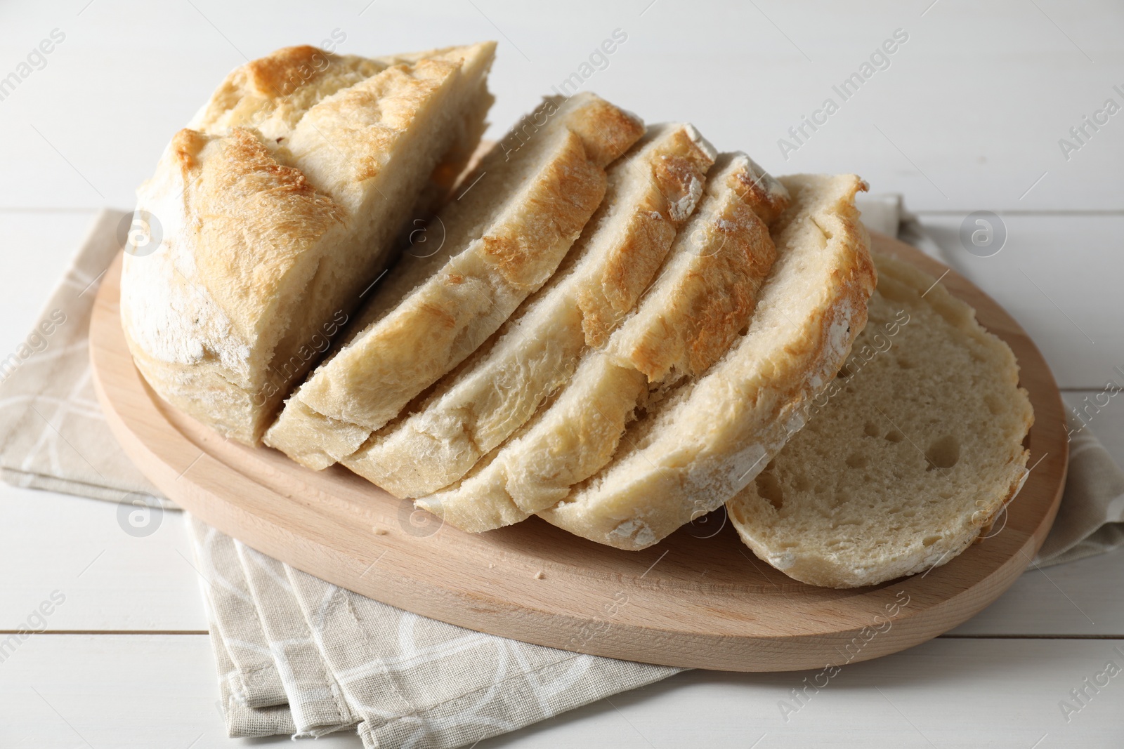 Photo of Freshly baked cut sourdough bread on white wooden table