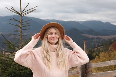Portrait of beautiful young woman in mountains on autumn day