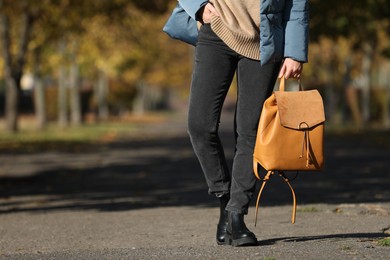 Young woman with stylish backpack on autumn day, closeup. Space for text