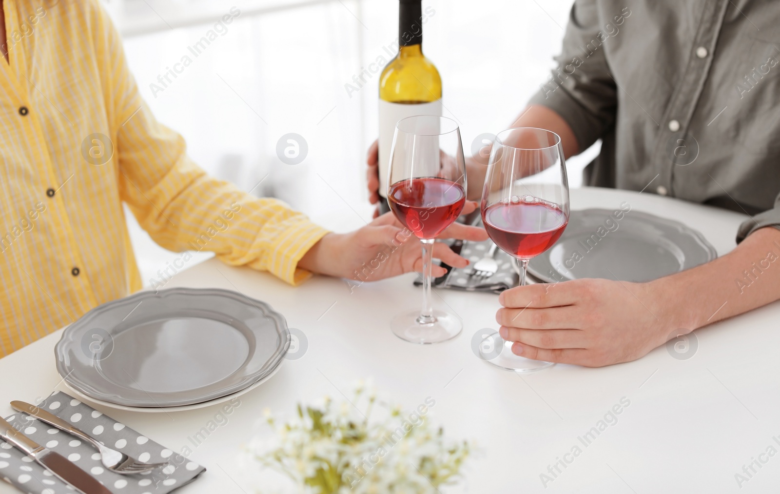 Photo of Young couple with glasses of wine at table in restaurant