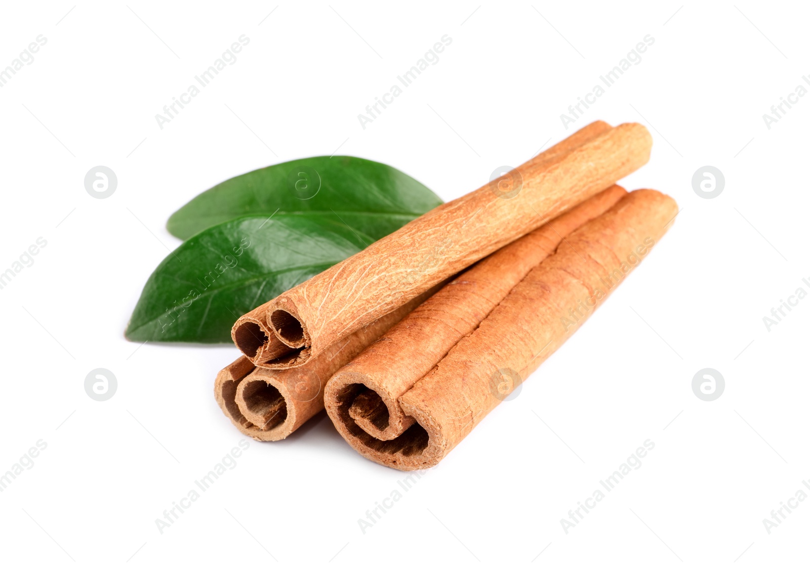 Photo of Cinnamon sticks and green leaves isolated on white